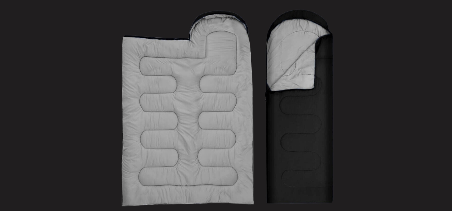 Two sleeping bags laid side by side, one light gray open to show channel quilting, the other black with gray lining on a dark background.