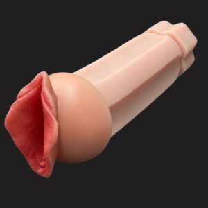 Close-up of a pale pink silicone finger prosthesis against a dark background, showing lifelike folds and knuckles.